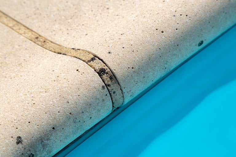 Closeup of stone coping on the edge of swimming pool