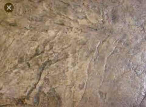 Close-up texture of weathered concrete or stone surface with cracks and discoloration